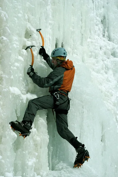 Man climbing frozen waterfall — Stock Photo, Image