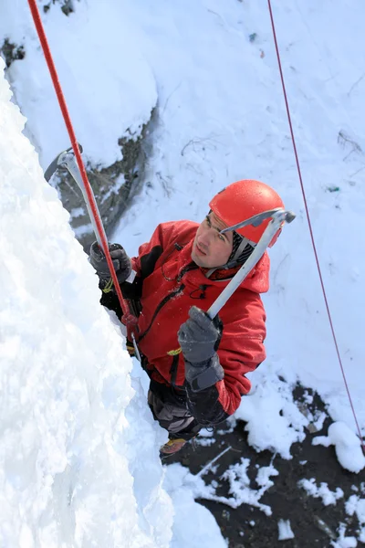 Man climbing frozen waterfall — Stock Photo, Image