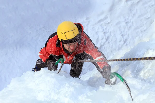 Man climbing frozen waterfall — Stock Photo, Image