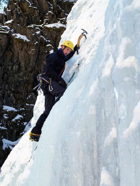 Man climbing frozen waterfall Royalty Free Stock Images