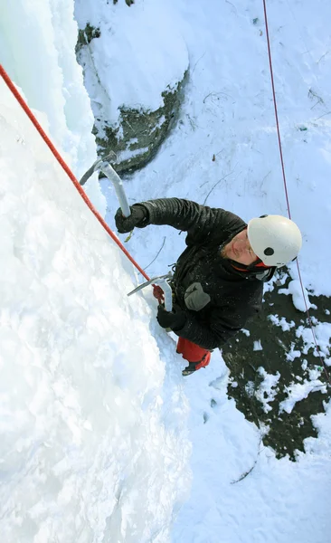 Homem escalando cascata congelada — Fotografia de Stock