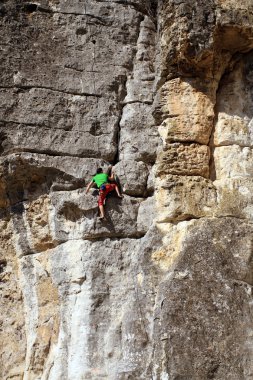 genç adam arka planda Vadi Manzaralı dikey duvar tırmanışı