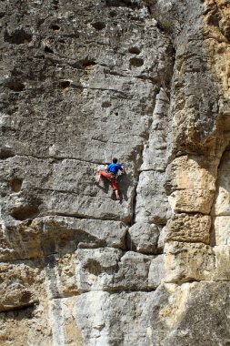 genç adam arka planda Vadi Manzaralı dikey duvar tırmanışı