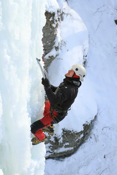 Homem escalando cascata congelada — Fotografia de Stock