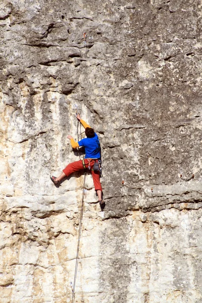 Jeune homme escalade mur vertical avec vue sur la vallée sur le fond — Photo