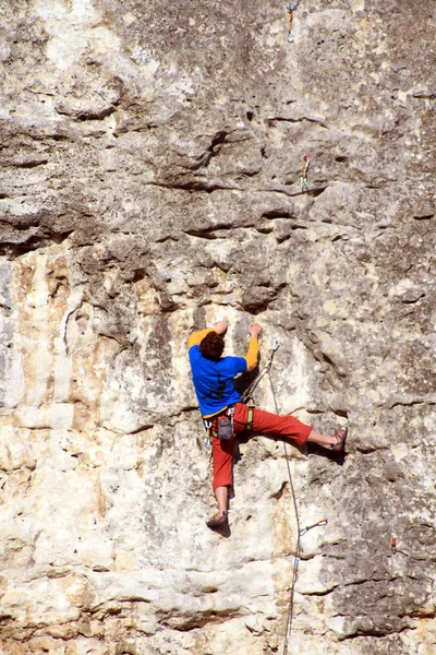 Genç adam arka planda Vadi Manzaralı dikey duvar tırmanışı — Stok fotoğraf