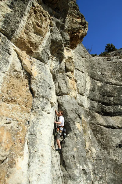 Giovane arrampicata parete verticale con vista valle sullo sfondo — Foto Stock