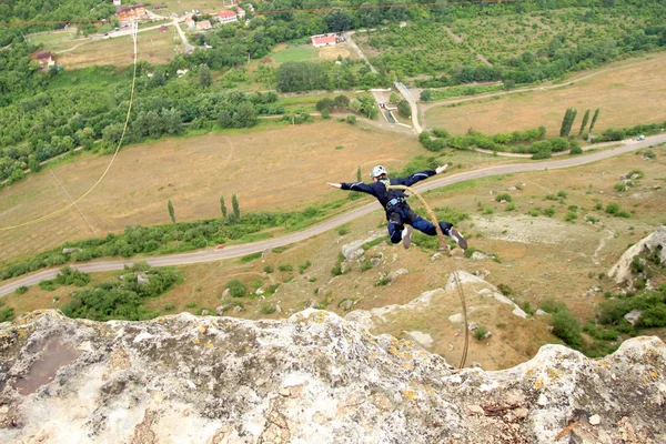 Jump off a cliff with a rope. — Stock Photo, Image