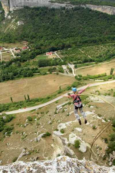 Mit einem Seil von einer Klippe springen. — Stockfoto