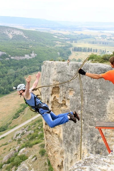 Springen van een rots met een touw. — Stockfoto