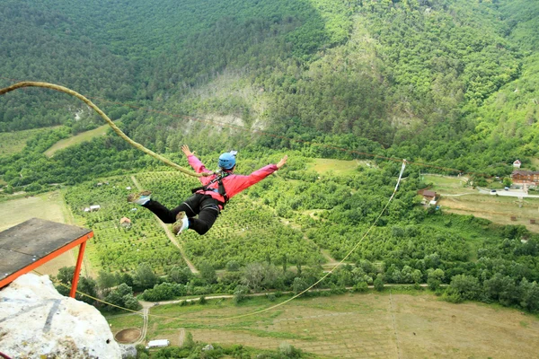 Mit einem Seil von einer Klippe springen. — Stockfoto