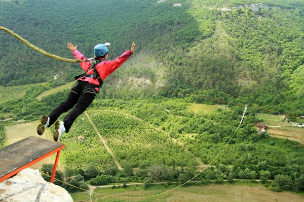 Mit einem Seil von einer Klippe springen. — Stockfoto