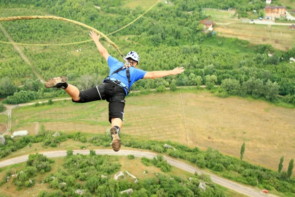 Jump off a cliff with a rope. — Stock Photo, Image