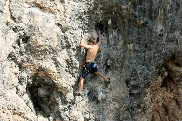 Jeune homme escalade mur vertical avec vue sur la vallée sur le fond — Photo