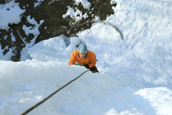 Man klättring frusna vattenfall — Stockfoto