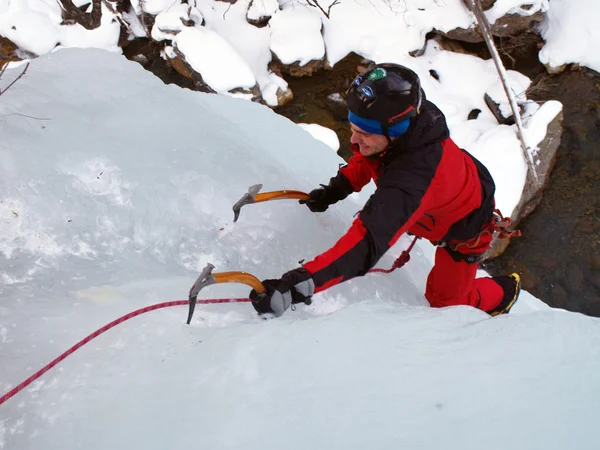 Man climbing frozen waterfall — Stock Photo, Image