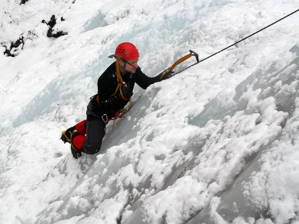 Man climbing frozen waterfall — Stock Photo, Image