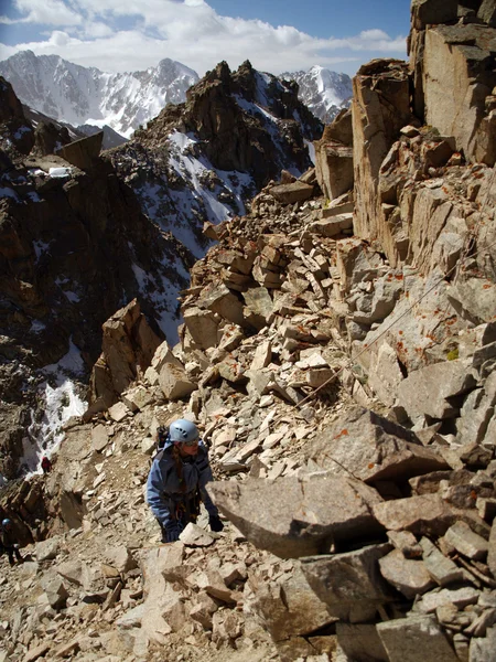 Giovane arrampicata su una parete calcarea con ampia valle sullo sfondo — Foto Stock