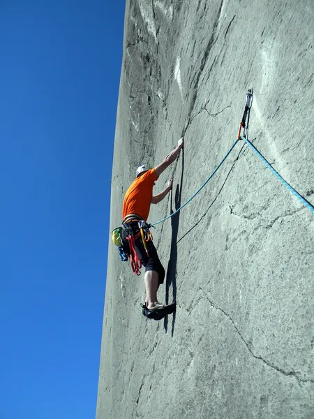 Young man climbing on a limestone wall with wide valley on the background — Stock Photo, Image