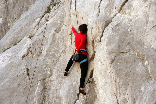 Joven escalando en una pared de piedra caliza con amplio valle en el fondo —  Fotos de Stock