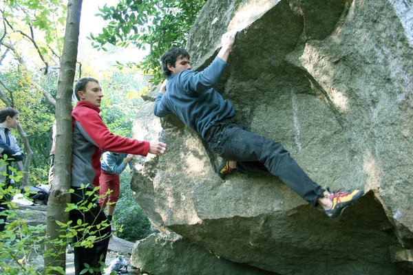 Joven escalando en una pared de piedra caliza con amplio valle en el fondo — Foto de Stock