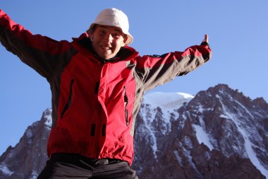 Sırt çantalı yürüyüşçüler dağın tepesinden vadi manzarasının keyfini çıkarıyorlar.