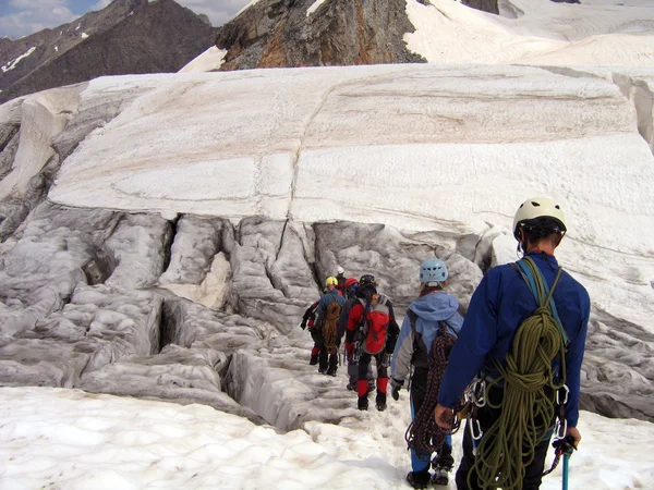 Wandelaars met rugzakken genieten van het uitzicht op de vallei vanaf de top van een berg — Stockfoto