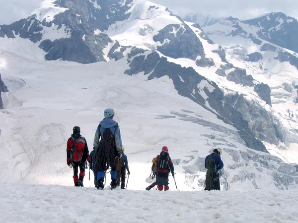 Senderistas con mochilas disfrutando de la vista del valle desde la cima de una montaña —  Fotos de Stock