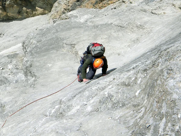 Giovane arrampicata su una parete calcarea con ampia valle sullo sfondo — Foto Stock