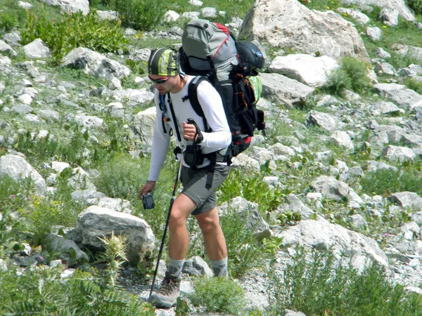 背负背包的徒步旅行者从山顶俯瞰山谷 — 图库照片