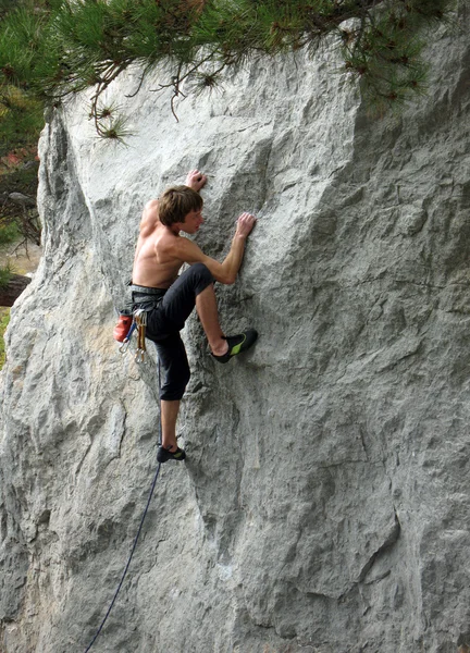 Joven escalando en una pared de piedra caliza con amplio valle en el fondo —  Fotos de Stock