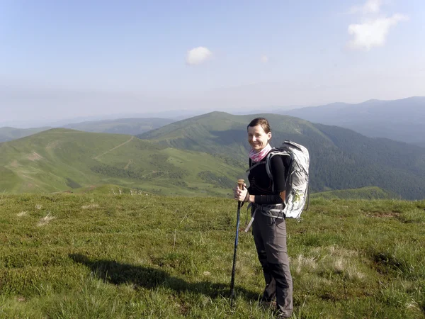 Caminhantes com mochilas desfrutando de vista do vale do topo de uma montanha — Fotografia de Stock