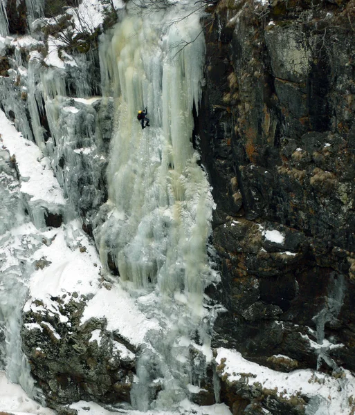 Человек карабкается на ледяной водопад — стоковое фото