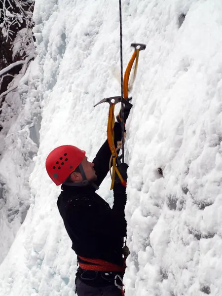 Man climbing frozen waterfall — Stock Photo, Image