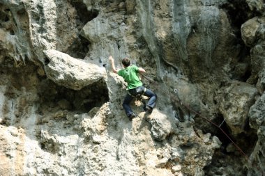genç adam arka planda Vadi Manzaralı dikey duvar tırmanışı