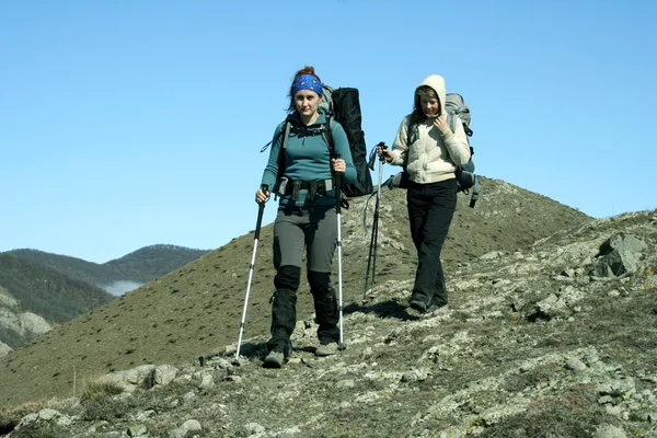 Turyści z plecakami cieszący się widokiem z góry na dolinę — Zdjęcie stockowe