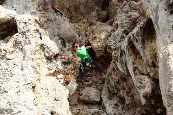 Jeune homme escalade mur vertical avec vue sur la vallée sur le fond — Photo