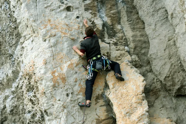 Jeune homme escalade mur vertical avec vue sur la vallée sur le fond — Photo