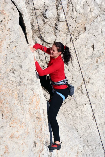 Jovem mulher subindo em uma parede de calcário com amplo vale no fundo — Fotografia de Stock