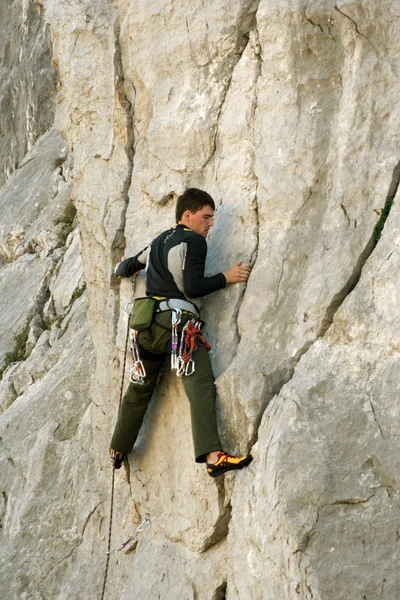 뒤에 넓은 계곡이 있는 석회암 벽을 타고 오르는 젊은이 — 스톡 사진