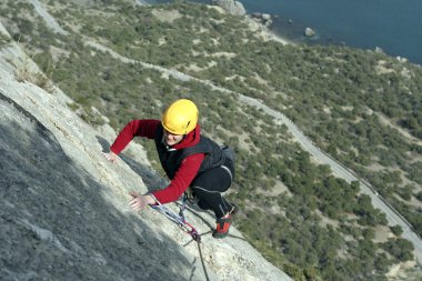 arka planda geniş vadi ile kireçtaşı duvara tırmanırken genç bir kadın