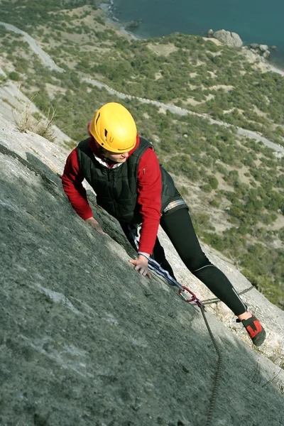 arka planda geniş vadi ile kireçtaşı duvara tırmanırken genç bir kadın