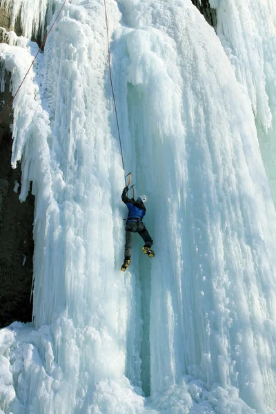 Man climbing frozen waterfall — Stock Photo, Image