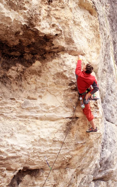 Joven escalando en una pared de piedra caliza con amplio valle en el fondo —  Fotos de Stock