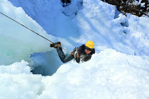 Homem escalando cascata congelada — Fotografia de Stock