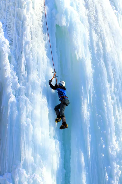 Man climbing frozen waterfall — Stock Photo, Image