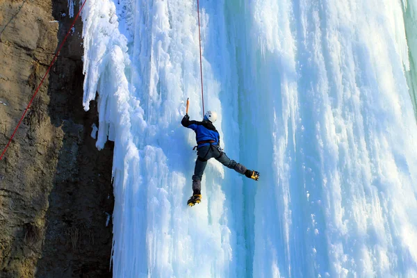 Mann klettert auf gefrorenen Wasserfall — Stockfoto
