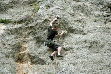 genç adam arka planda Vadi Manzaralı dikey duvar tırmanışı