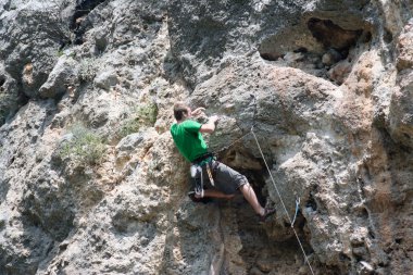 genç adam arka planda Vadi Manzaralı dikey duvar tırmanışı