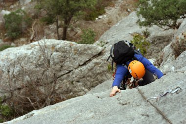 genç adam arka planda Vadi Manzaralı dikey duvar tırmanışı